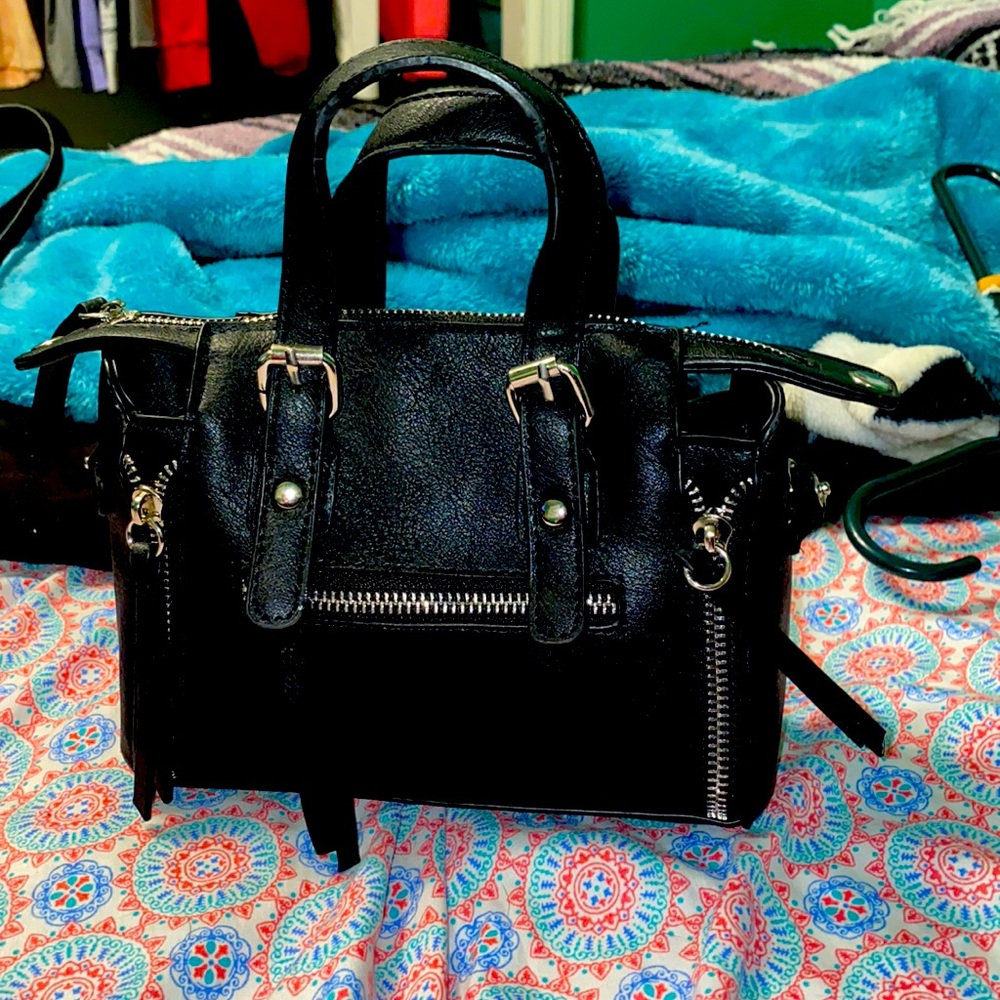 Small black purse with detachable strap.